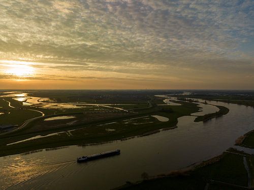 Schip vaart op de IJssel tijdens zonsondergang