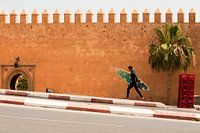 Surfer in front of Kasbah des Oudayes, Rabat, Morocco