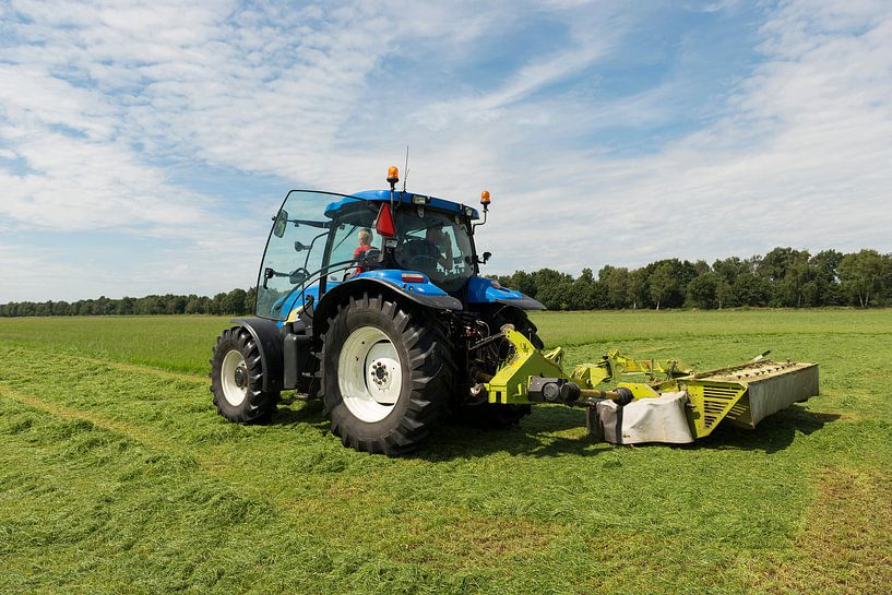 weiland maaien met blauwe tractor en maaimachine van Tonko Oosterink