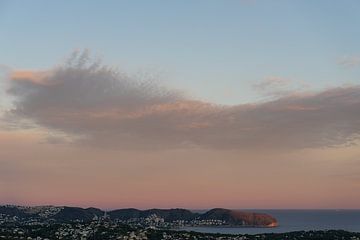 Lichtroze lucht en pluizige wolken bij zonsondergang van Adriana Mueller