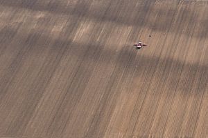 Luftaufnahme eines Traktors, der eine landwirtschaftliche Legemaschine zieht