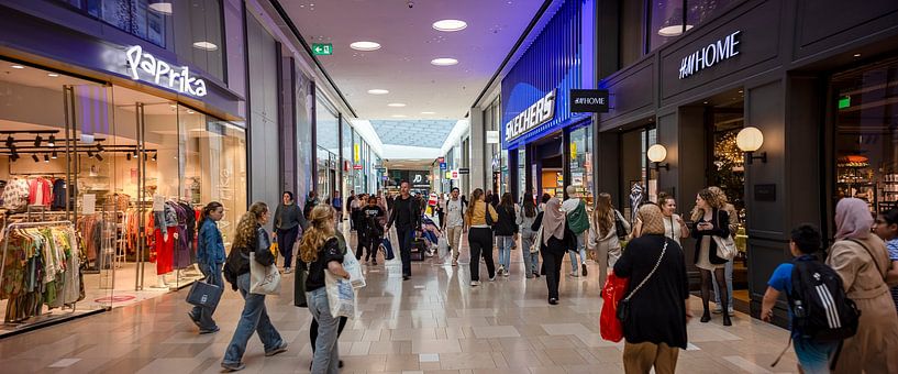 Cosily busy in indoor shopping centre by Maarten Zeehandelaar
