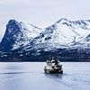 Bergen en vissersboot in de winter bij Harstad in Noorwegen van Rico Ködder