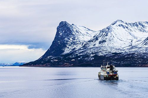 Montagnes et bateau de pêche en hiver près de Harstad en Norvège