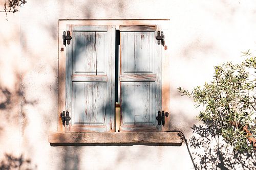 Schaduwspel op oude muur met houten luiken