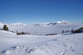 The snow-capped peaks of the Rax Mountains rise above a sea of clouds by Tomherkules