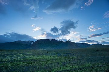 IJsland - Majestueuze besneeuwde bergen achter groene lavavelden bij zonsopgang van adventure-photos