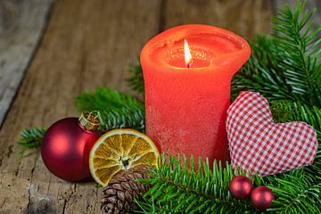 Advents- und Weihnachtskerze mit rotem Herz und traditioneller Dekoration auf Holz von Alex Winter