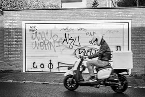 Zwart-witte straatfoto van scooter en graffiti