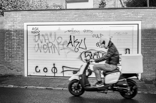 Zwart-witte straatfoto van scooter en graffiti