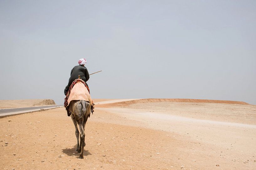 Egyptische man in traditionele kleding op kameel in de woestijn bij Gizeh. van Marjolein Hameleers