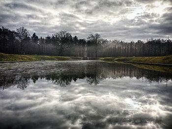 Mistige landschap met een adembenemende reflectie van de wolken (Baarn).