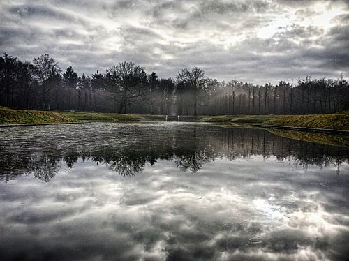 Mistige landschap met een adembenemende reflectie van de wolken (Baarn).