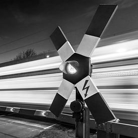 Level crossing with speeding train passing by by Frank Herrmann