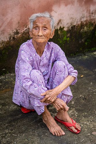Femme âgée aveugle assise sur sa pantoufle à Hoi An