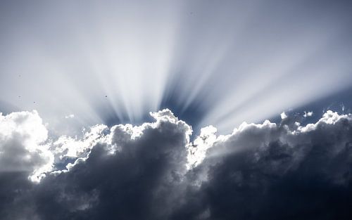 Zonnestralen in de wolken