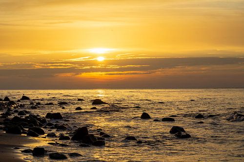 Coucher de soleil sur la plage avec de gros rochers dans l'eau sur la mer Baltique à Rügen