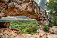 Een man onder de rotsboog bij Cerro Arco in Tobati, Paraguay.