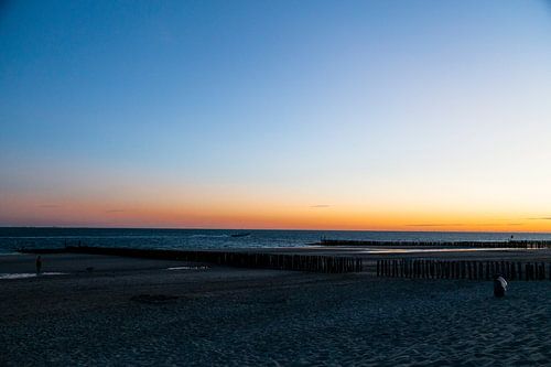 photo de plage capture la lumiere chaude d'un coucher de soleil poteaux en bois