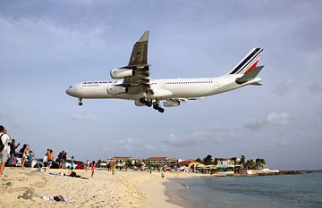 Airbus A340 vliegt laag over Maho Beach, Sint Maarten (SXM) van Ramon Berk
