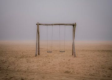 De eenzame schommel op het strand in de mist van Robby's fotografie