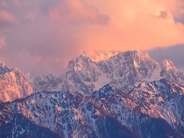 Een prachtige weerkaatsing van de ondergaande zon op een besneeuwde bergtop in Oostenrijk van Lucie Lindeman
