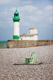 Bank mit Leuchtturm am Strand in Frankreich, Normandie