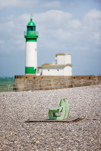 Bench with a lighthouse on the beach in France, Normandy