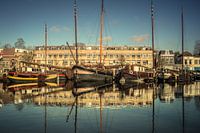 historische zeilboten met  reflectie in haven van Gouda