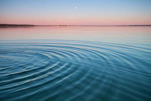 The turquoise lake at dawn.small symmetrical waves of blue and turquoise lake surface at dawn, red a
