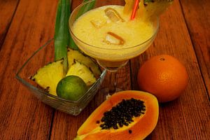 tropischer Cocktail mit Ananas, Limette, Papaya, Orange.