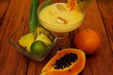 Tropische cocktail met ananas, limoen, papaya, sinaasappel.