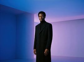 Confident Man in Black Coat Against Gradient Backdrop by Markus Gann
