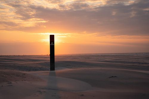 Beach post in front of the sun