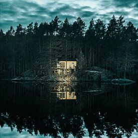 Oplichtende hut aan reflecterend meer met dramatische lucht van Joep van de Zandt