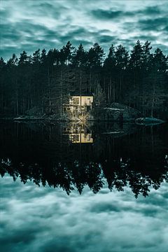 Oplichtende hut aan reflecterend meer met dramatische lucht van Joep van de Zandt