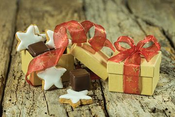 Kerstgebak en chocolade in geschenkdoos met rood lint op houten tafel van Alex Winter