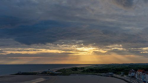 Zonneharpen door donkere wolken boven de Westerschelde