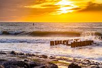 Golven op de dijk met zonsondergang