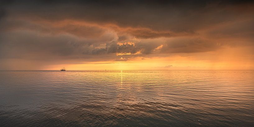 Atmosphere image of a fishing boat on the mud flats between two small showers by Harrie Muis