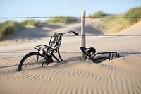 Fiets bedolven onder het zand