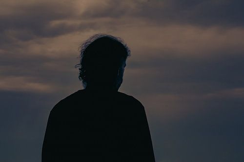 Mannelijke silhouet voor de wolken