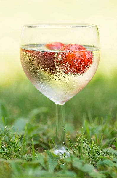 Een glas vol zomer (cocktail van wijn en een aardbei in glas met druppels) van Birgitte Bergman