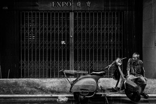 Old man in the streets of Bankok in the rain