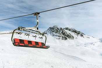 Rot-schwarzer Sessellift oberhalb der Piste - Wintersport