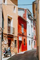 Bunte Straße mit Motorrad in spanischem Dorf