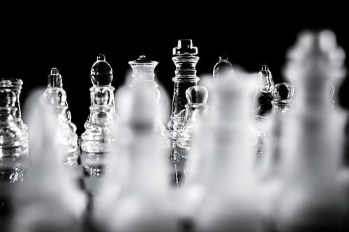 Schwarze und weiße Glas Schachfiguren auf Schach Brett