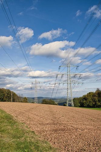 High-voltage pylon with overhead line in landscape