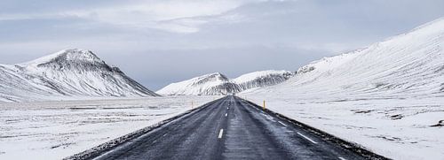Weg door het besneeuwde berglandschap in IJsland