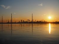 La silhouette d'une raffinerie de pétrole.